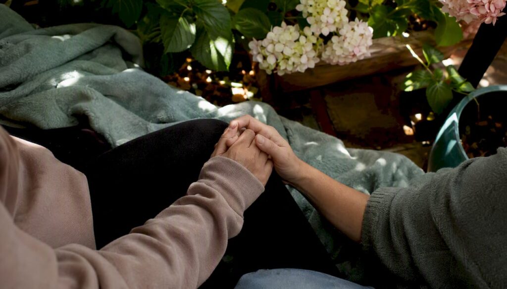 Partners holding hands after birth trauma