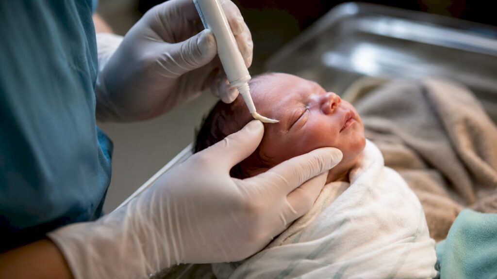 Clinician applying ointment to newborn eye